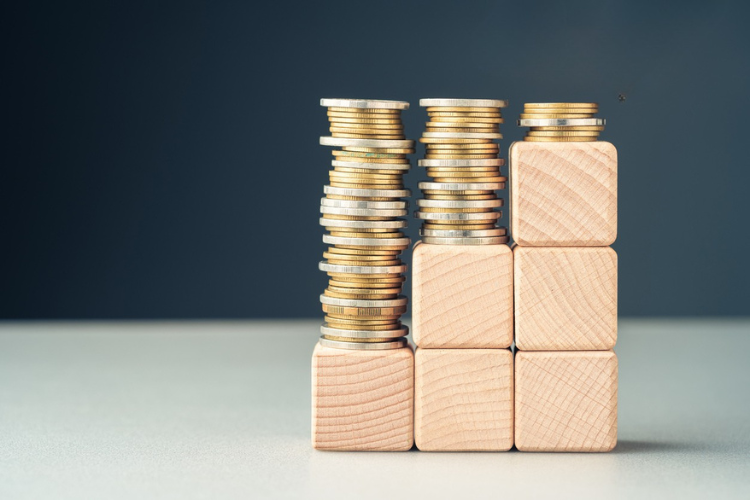 Three stacks of wooden blocks with coins stacked on top