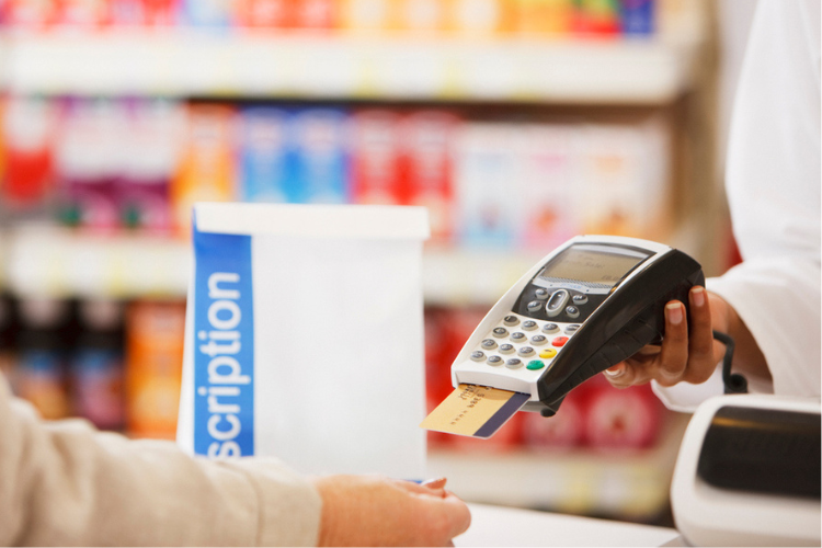 Pharmacist holding security device for customer in drug store