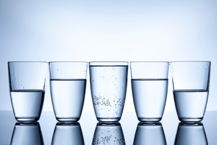 Stock photo of glasses with water in various capacities.